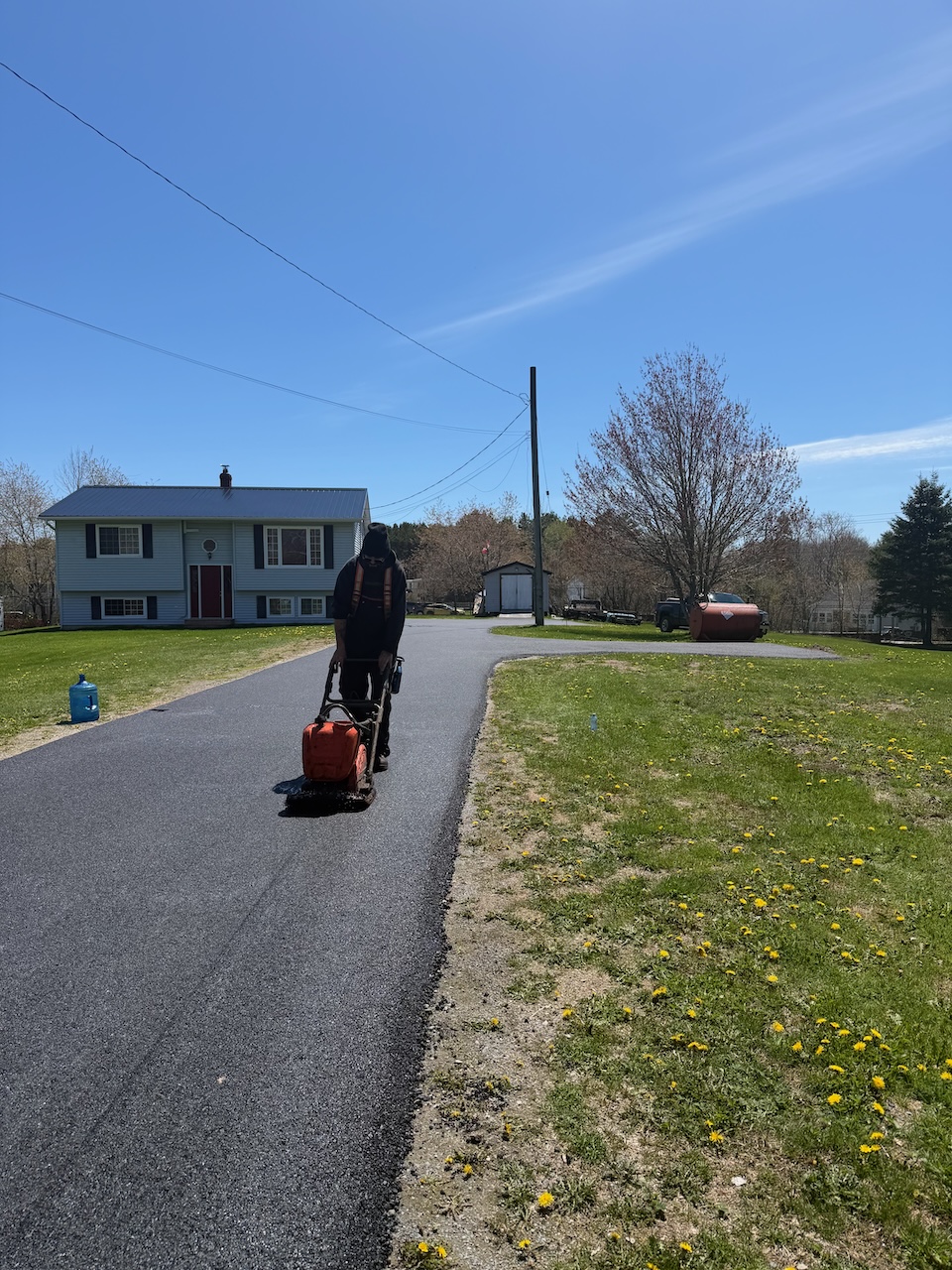 Empire Paving crew finishing a new residential asphalt driveway